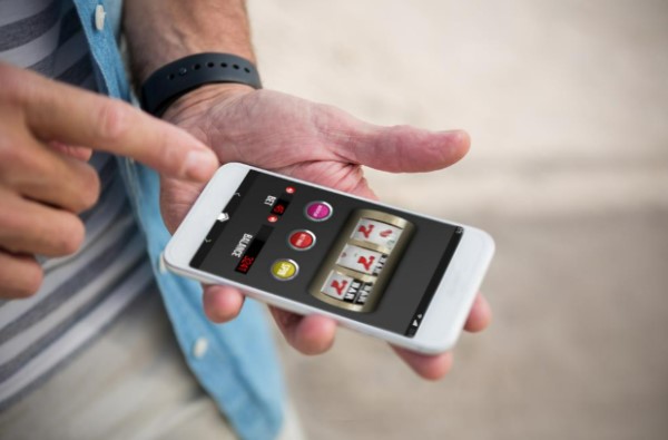 En mand spiller online casinospil fra sin telefon.